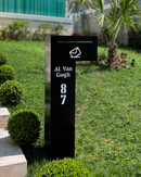 Caixa de correio Itu preta em ACM personalizada com endereço instalada em jardim de condomínio