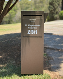 Caixa de correio E-Commerce em ACM Marrom personalizada com LED instalada em jardim de fachada residencial
