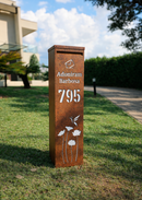 Caixa de correio Slim em ACM corten com recorte floral personalizado instalada em jardim
