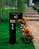 Caixa de correio Itu preta com LED iluminada à noite em jardim colorido com flores