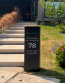 Caixa de correio Vinhedo preta personalizada com LED ao lado de escada lateral em jardim durante o dia
